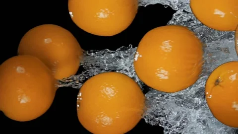 Group of oranges is bouncing horizontally with splashes on the black background Stock Footage 202287036