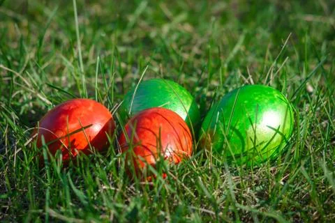 Group of painted easter eggs on the bright spring grass. Easter hunt. Closeup Stock Photos