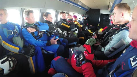 Group of parachutists sits inside a small plane awaiting a jump Video stock 96509779