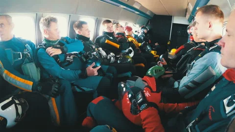 Group of parachutists sits inside a small plane awaiting a jump Video stock 96580451