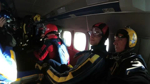 Group of parachutists sits inside a small plane awaiting a jump. Slow Motion Video stock 96590488