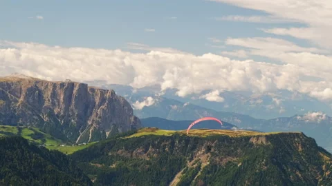 Group of paragliders flies over green highland in mountains Stock Footage 220172589