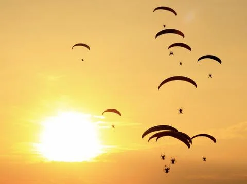 Group of paragliding on the sunset background Stock Photos