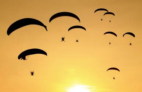Group of paragliding on the sunset background Stock Photos