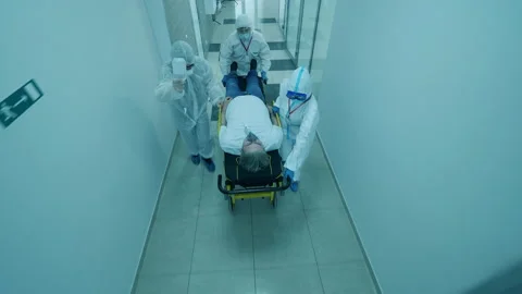 Group of paramedics are pushing a table with a patient on it Stockbeeldmateriaal 130879680