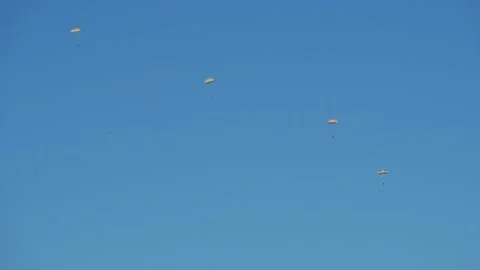 A group of paratroopers one after another dropping in a cloudless blue sky. Stock Footage 147457379