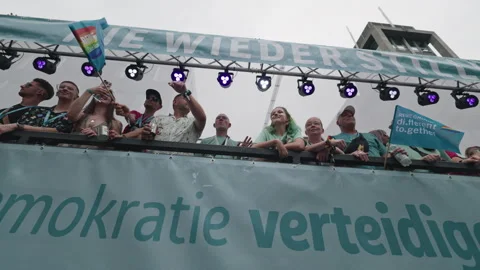 Group of participants stands on a parade float decorated with banners reading Video stock 346239461