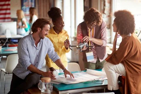 Group of people analyzing drone for their business needs, looking at it and t Stock Photos