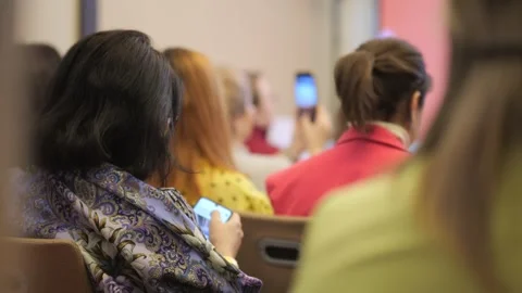 Group of people are sitting in a classroom and using their cell phones Stock Footage 308872573
