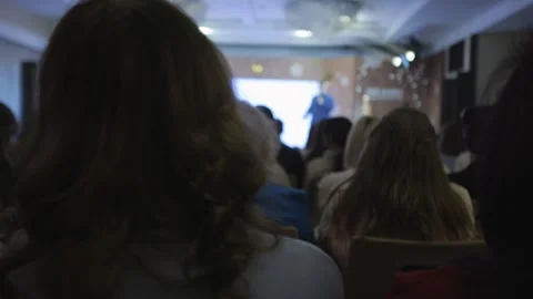Group of people are sitting in a room with a projector screen Stock Footage 304773604