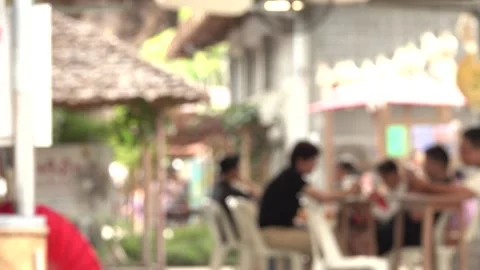 A group of people are sitting at tables outside a restaurant Stock Footage 289328572