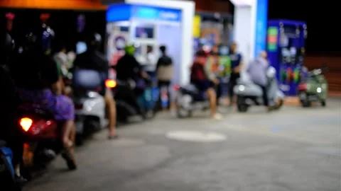 A group of people are standing around a gas station Stock Footage 295112286