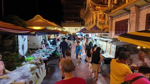 A group of people are walking down a street with a market Видео 318098180