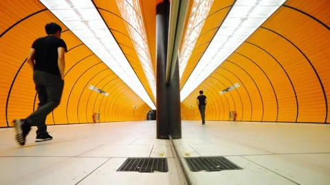 A group of people are walking through a tunnel with orange walls Stock Footage 314611644