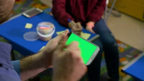 Group of people brainstorming in a workshop and man holding smartphone with.. Stock Footage