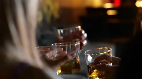 Group of people celebrating while holding glasses with whiskey and toasting in Stock Footage 255151728