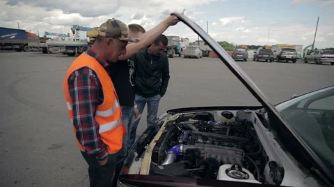 A group of people check the condition of the car engine Stock Footage