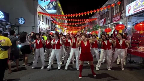 Group of people dance joyfully under glowing red lanterns at Lebuh Presgrave 動画素材 327805221