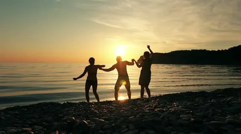 Group of people dancing on the beach at sunset.  Stock Footage 21931801