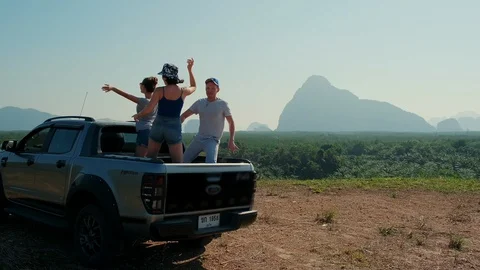 A group of people dancing with hands up in the back of a pickup truck Stock Footage 129866529