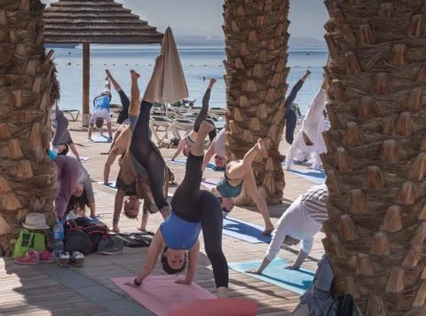 Group of people of different ages, from different countries doing yoga on the Stock Photos