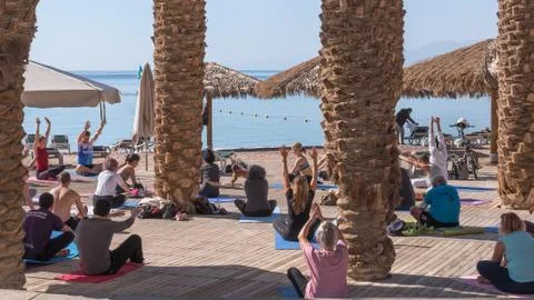 A group of people of different ages, from different countries doing yoga on t Stock Photos
