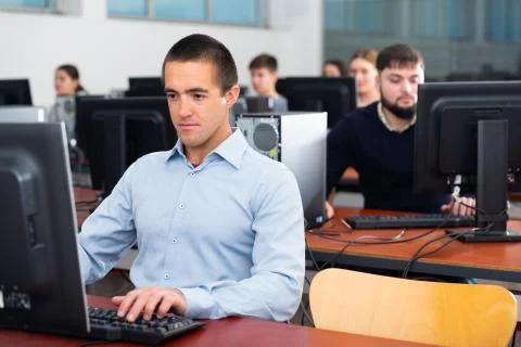 Group of people of different ages learning to use computers in classroom Stockfoto's