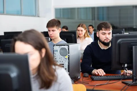 Group of people of different ages learning to use computers in classroom Stockfoto's