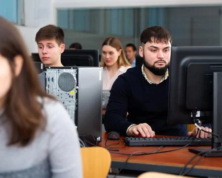 Group of people of different ages learning to use computers in classroom 스톡 사진