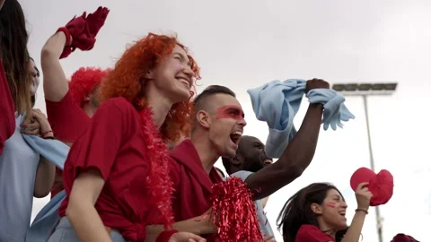A group of people of different races and ages follow the soccer game in the Stock Footage 162293329