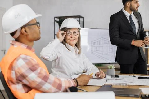 Group of people discussing construction project indoors. Stock Photos
