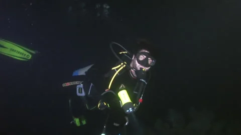 Group of people in diving gear diving near sea bed in dark. Stock Footage 235000687