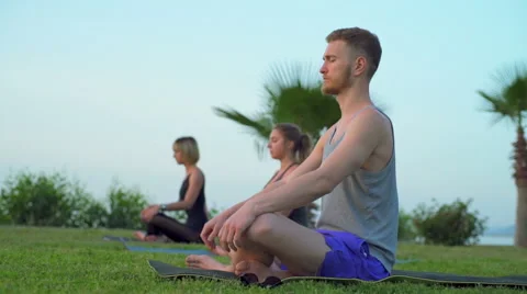 Group of people doing breathing practice sitting on grass Stock Footage 63049484