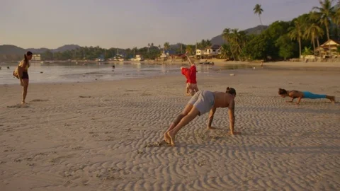 Group of people doing different yoga poses on the beach Stock Footage 75286641