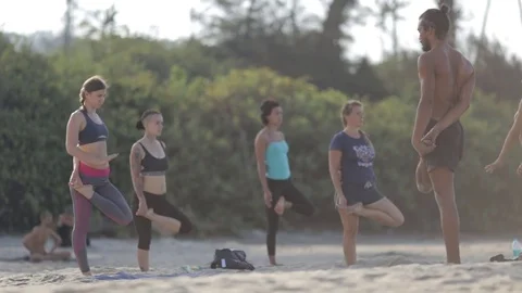 A group of people doing yoga on the beach. Stock-Footage 73917983