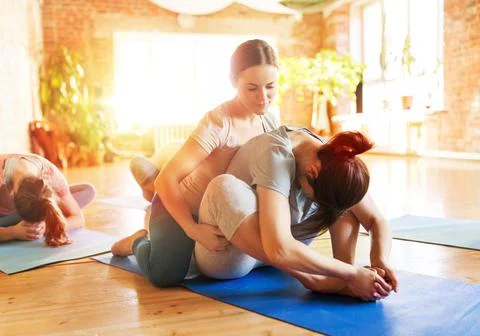 Group of people doing yoga exercises at studio Stock Photos