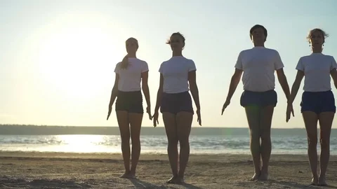 Group of people doing yoga pose namaste seaside sundown rapid slow motion Stock Footage 78752589