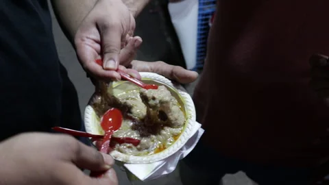 Group-of-people-eating-haleem-from-single-bowl Stock Footage 245877831