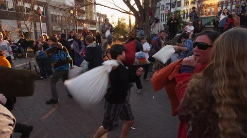 Group of people enjoying while fighting with pillows at pillow fight festival Stock Footage 103421891
