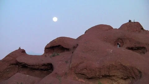Group of People Exploring Hole in the Rock with Full Moon Papago Park Phoenix AZ Stockbeeldmateriaal 322726425
