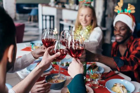 Group of people at a festive table clink glasses Stock Photos