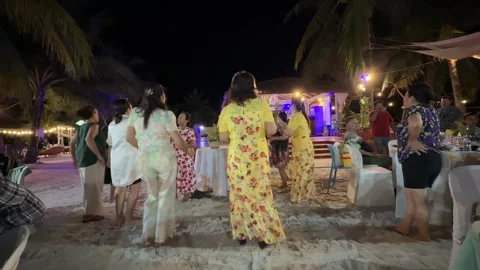 Group of People Gathered and Dancing on Sandy Beach at Night 스톡 동영상 337083273