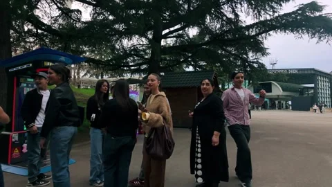 Group of people gathering under a large tree at Mtatsminda Park funicular 库存影片 334614272