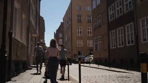 A group of people go walking down the street from the back Stock Footage 111942797