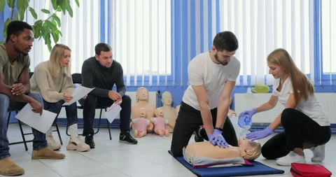 Group of people with instructor practicing CPR on mannequin at first aid class Stock Footage 163968586