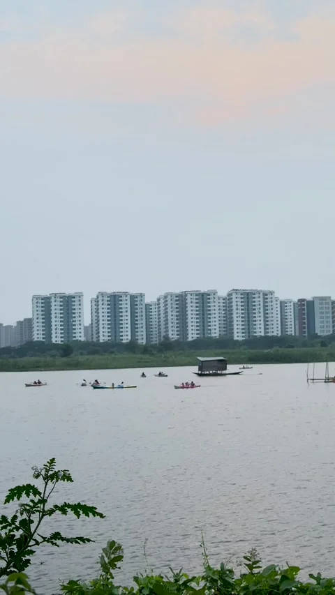 Group of people kayaking on a calm river with a modern high-rise apartment .. Stock-Footage 337788567