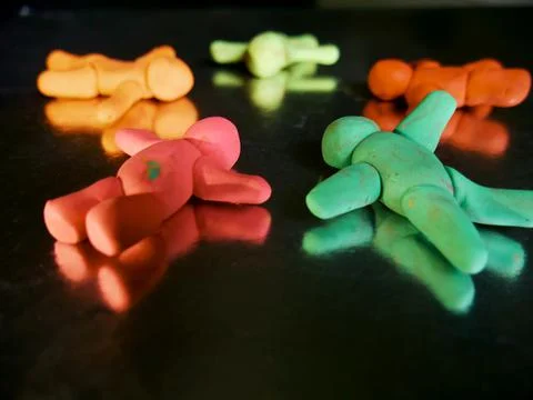 Group of people lying on circular shape made with clay 스톡 사진