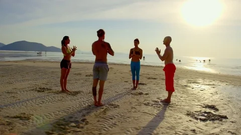 Group of people meditating on beach during sunset Stock Footage 75291632