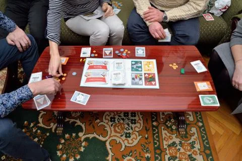 A group of people playing a game Nefarious on the coffee table Stock Photos