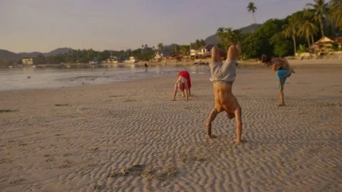 Group of people practicing different yoga poses on the beach Stock Footage 75290542